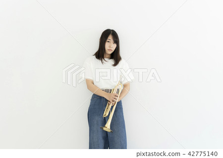 A woman blowing a trumpet 42775140
