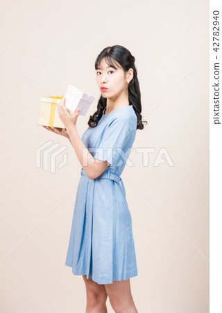Cute woman giving a gift Cute woman giving a gift 42782940