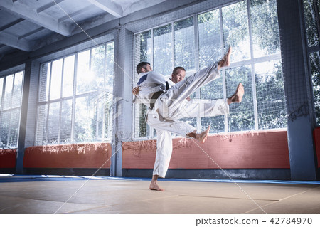 Two judo fighters showing technical skill while practicing martial arts in a fight club 42784970