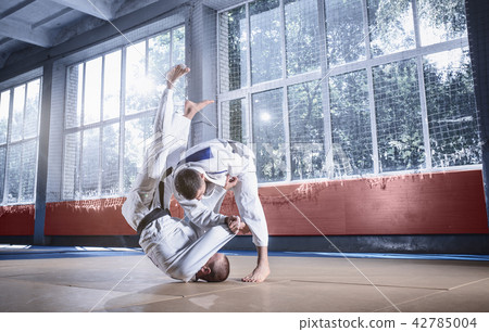 Two judo fighters showing technical skill while practicing martial arts in a fight club 42785004