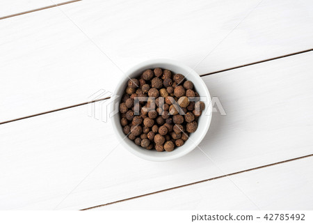 Allspice in white bowl. Close up 42785492