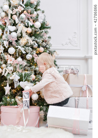 Cute baby and christmas gifts. Little child having fun near Christmas tree in living room. Loving 42786866