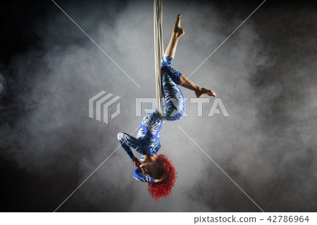 athletic sexy aerial circus artist with redhead in blue costume making tricks on the aerial silk athletic sexy aerial circus artist with redhead in blue costume making tricks on the aerial silk 42786964