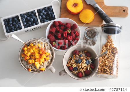 Breakfast set. Porridge with sliced apricot, berries and granola Breakfast set. Porridge with sliced apricot, berries and granola 42787114