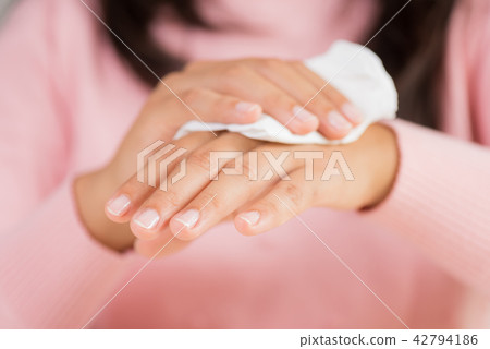 Woman cleaning her hands with a tissue Woman cleaning her hands with a tissue 42794186