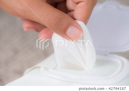 Woman hand holding wet wipes from package. Woman hand holding wet wipes from package. 42794187