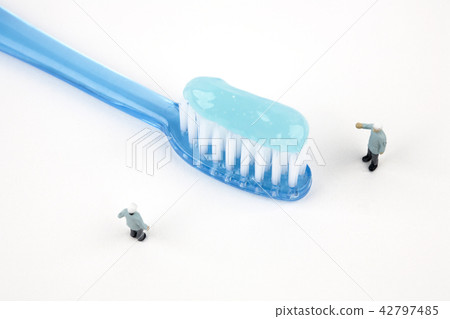 Miniature people with a toothbrush on white background 42797485