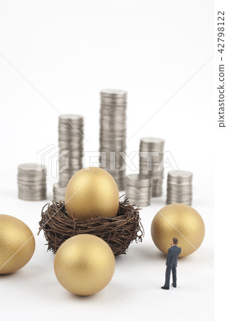 商人用金黃雞蛋和硬幣聳立 商人用金黃雞蛋和硬幣聳立 42798122