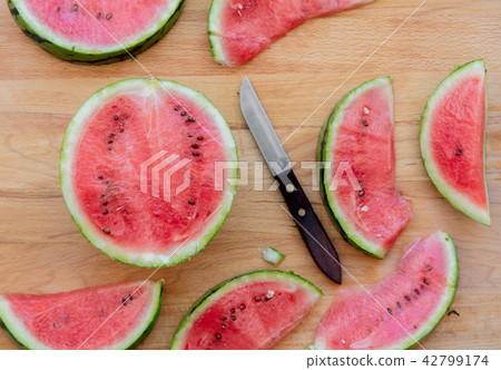 Watermelon and knife on wooden table Watermelon and knife on wooden table 42799174