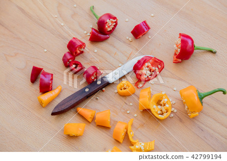 cut yellow and red peppers with knife cut yellow and red peppers with knife 42799194