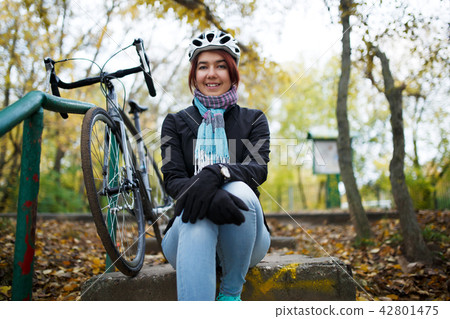 Image of girl sitting on stairs next to bicycle 42801475