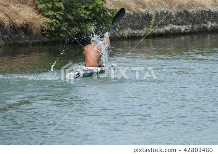 muscular  man shirtless  rowing in the channel  42801480