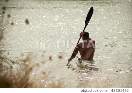 muscular  man shirtless  rowing in the channel  42801482