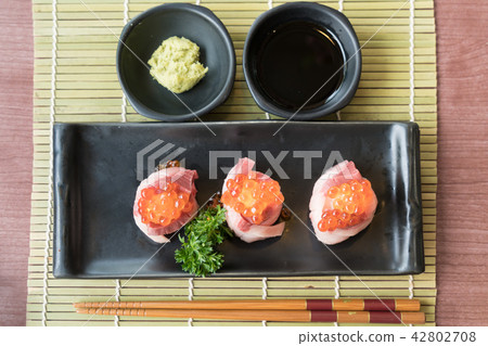 Salmon Roe on Hamachi sushi on black plate Salmon Roe on Hamachi sushi on black plate 42802708