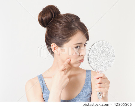 A woman troubled watching a mirror 42805506