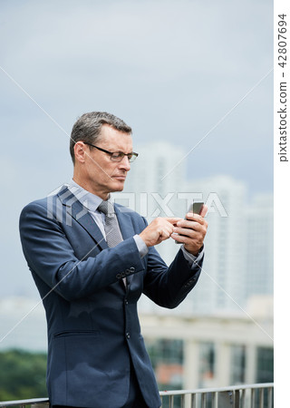 Businessman reading text messages 42807694
