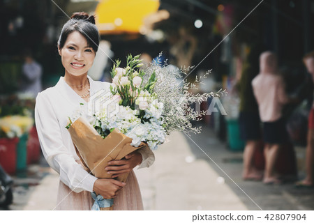 Cheerful woman with flowers Cheerful woman with flowers 42807904