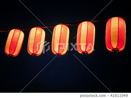 Paper red-white asian japanese chinese lanterns chochin akachochin shines on dark sky. A garland of 42811049