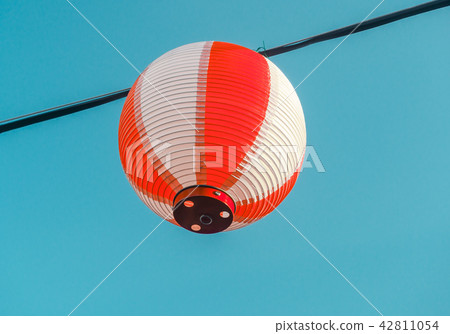 Paper red-white japanese lanterns Chochin hanging on blue sky background Paper red-white japanese lanterns Chochin hanging on blue sky background 42811054