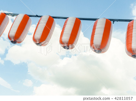 Paper red-white japanese lanterns Chochin hanging on blue sky background Paper red-white japanese lanterns Chochin hanging on blue sky background 42811057
