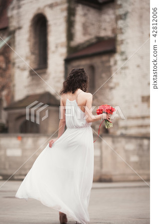 Beautiful young bride with bridal bouquet on the background church 42812006