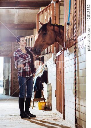 Beautiful woman with long dark braid coming to stable Beautiful woman with long dark braid coming to stable 42812582