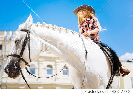Stylish cowboy girl wearing brown riding boots riding horse 42812720