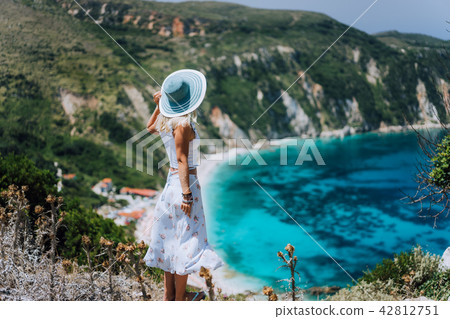 Young woman on Petani beach Kefalonia, admiring highly excited picturesque panorama of emerald blue 42812751