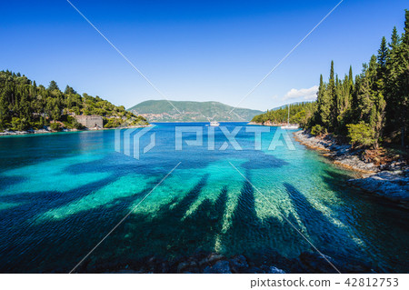 Beautiful Phoki Beach surrounded by cypress trees in the evening sunlight. Amazing seascape of Beautiful Phoki Beach surrounded by cypress trees in the evening sunlight. Amazing seascape of 42812753