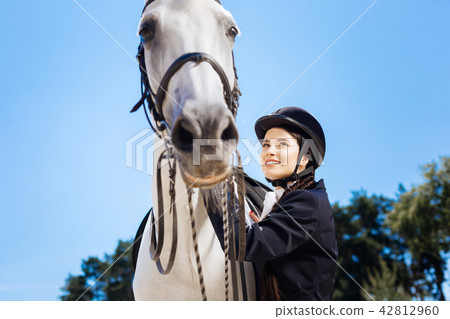 Dark-haired businesswoman loving equestrianism coming to race track Dark-haired businesswoman loving equestrianism coming to race track 42812960