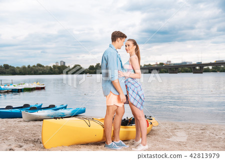 Beautiful young couple having romantic date near the river Beautiful young couple having romantic date near the river 42813979