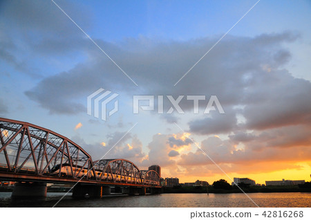 Keisei Skyliner crossing an iron bridge stained with sunset and orange color Keisei Skyliner crossing an iron bridge stained with sunset and orange color 42816268