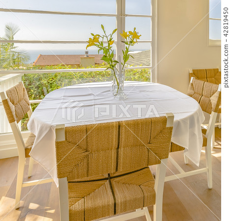 Bright window with flowers and wicker chairs 42819450