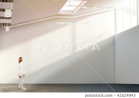 Woman walking near blank white wall mockup in modern gallery Woman walking near blank white wall mockup in modern gallery 42824943