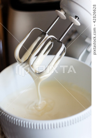Electric mixer being used to mix ingredients for Electric mixer being used to mix ingredients for 42826628