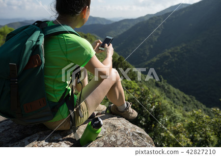 Woman hiker using smartphone on hiking travel 42827210
