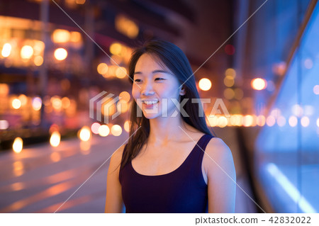 Happy Asian Woman Thinking Outdoors At Night Happy Asian Woman Thinking Outdoors At Night 42832022