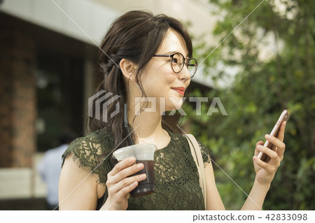 A woman watching a smartphone A woman watching a smartphone 42833098