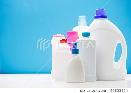 Photo of bottles of cleaning products on white table isolated on blue background 42835524