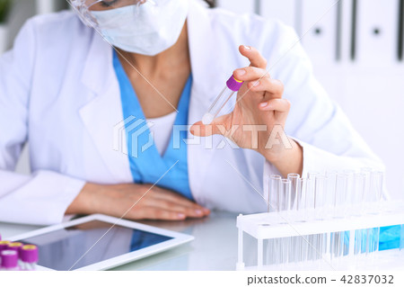 Female scientific research is looking at the tube in laboratory. Blood test concept Female scientific research is looking at the tube in laboratory. Blood test concept 42837032