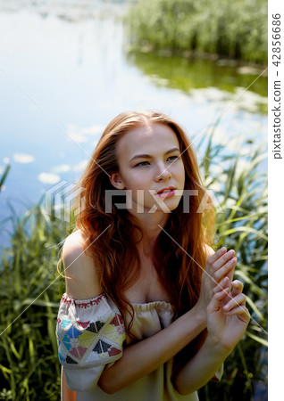 Portrait of a red-haired girl with long hair. Hair down. Artistic portrait. Child of nature 42856686
