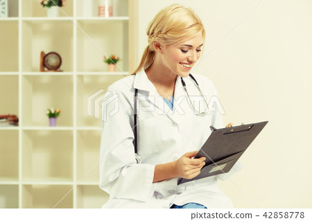 Young female doctor working in hospital office. 42858778