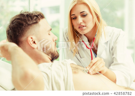 Woman Doctor and Male Patient in Hospital Office Woman Doctor and Male Patient in Hospital Office 42858782