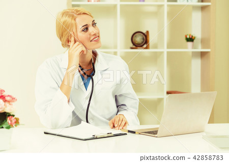 Young female doctor working in hospital office. Young female doctor working in hospital office. 42858783