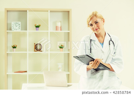 Young female doctor working in hospital office. 42858784