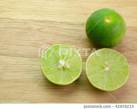 lemon with green leaf Put on wooden floor. 42859219