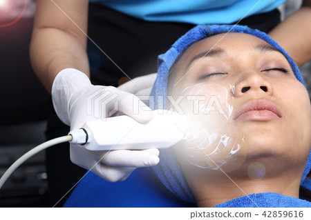 Treatment on Asian Woman as patient to make skin smooth bright and cure acne with medical beauty device instrument cold process on face in hospital clinic, acne wart 42859616