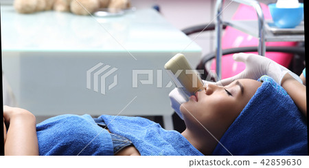 Treatment on Asian Woman as patient to make skin smooth bright and cure acne with medical beauty device instrument cold process on face in hospital clinic 42859630
