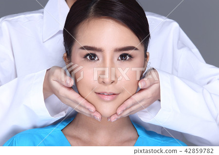 V Shape Face Checking diagnose by Beautician Doctor, put hands on patient face. Studio lighting white background isolated 42859782