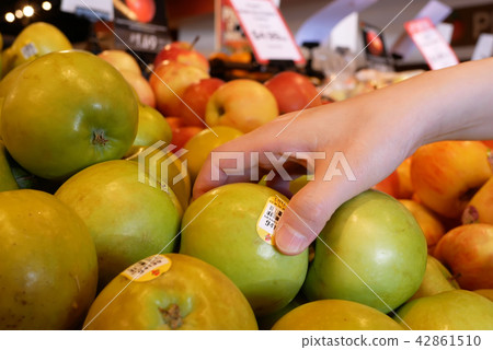 Motion of woman's hand picking ambrosia apple 42861510